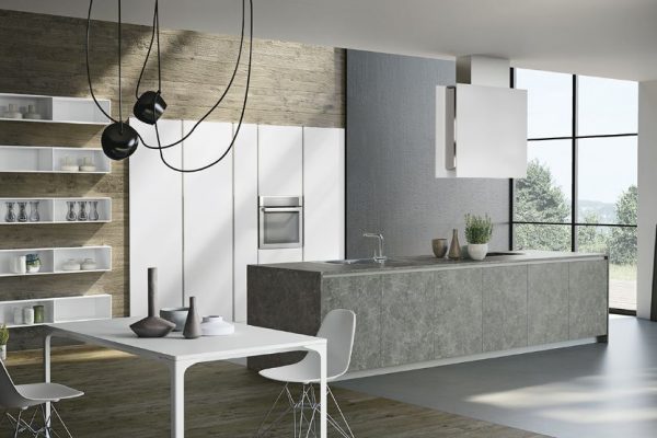 Moderne kjøkkne, med høyskap innbygd i vegggen. Kjøkkenøy med kokeløsning, laget i stein. Hvitt spisebord og stol til venstre i rommet.