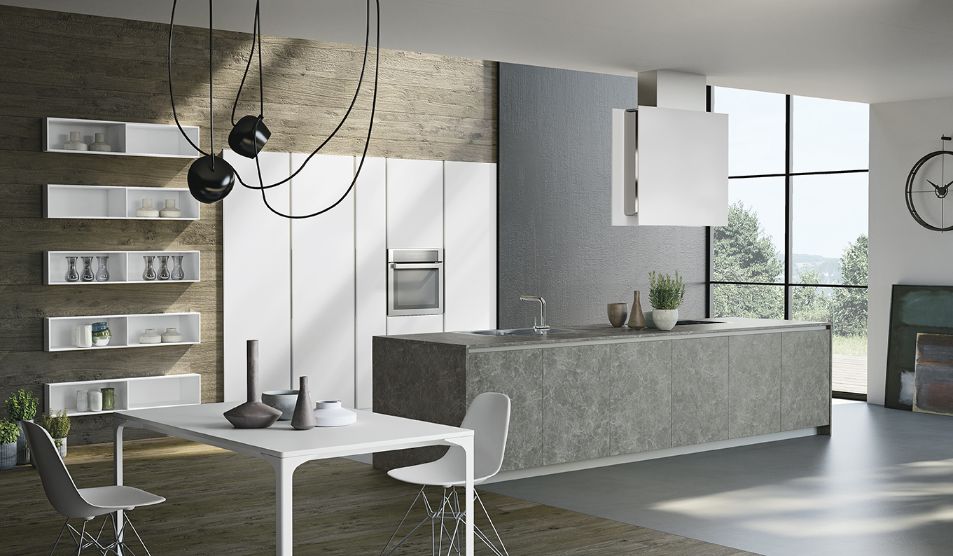 Moderne kjøkkne, med høyskap innbygd i vegggen. Kjøkkenøy med kokeløsning, laget i stein. Hvitt spisebord og stol til venstre i rommet.