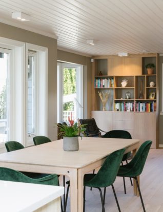 Stort deilig spisebord, mef flaskegrønne stoler, Bakers i stuen er en eikehylle og lekre grønne planter
